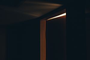 A door slightly ajar, with some light seeping into the dark room